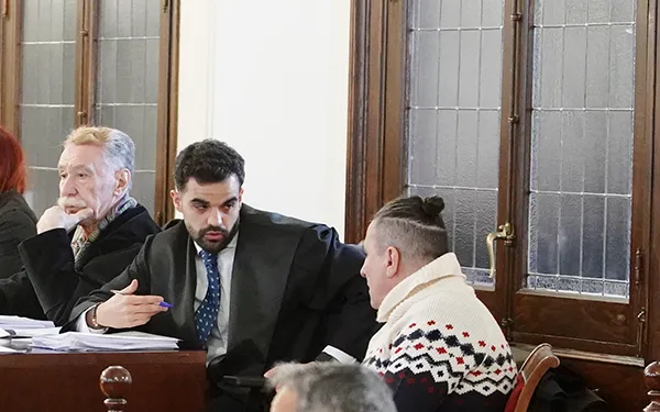 UNO DE LOS ACUSADOS CONVERSANDO CON SU LETRADO