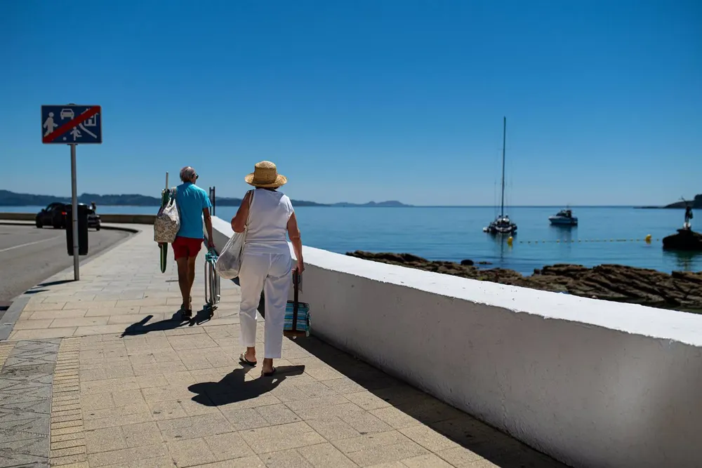 Una pareja camina hacia la playa en Pontevedra - Elena Fernández - EP